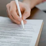 Tangan menandatangani dokumen surat serah terima barang